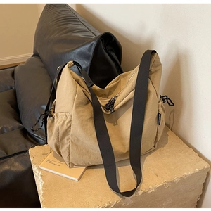 Macro shot of khaki canvas messenger bag with adjustable strap and side drawstring pocket
