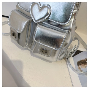 Silver metallic leather backpack featuring a large 3D heart and front lock pockets
