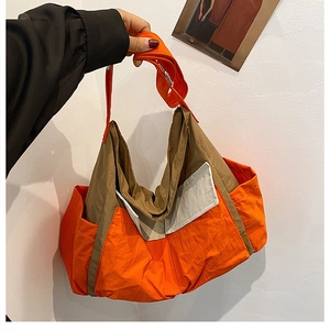 Detail of orange and khaki canvas messenger bag with adjustable strap and front pocket