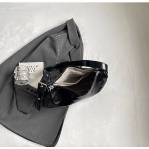 Detail of black crescent shoulder bag with interior pocket and silver buckle