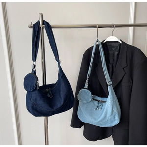 Detail of denim half-moon crossbody bags with matching round coin pouches and wide straps