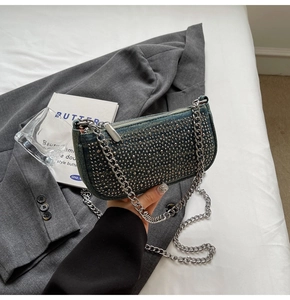 Close-up of vintage denim underarm bag featuring silver studs and metallic chain strap