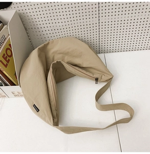 Detail view of the khaki nylon hobo bag featuring a side brand label and zipper closure