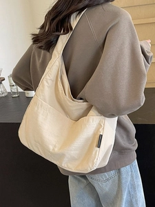 Minimalist beige oversized shoulder bag in nylon with front pocket for daily commute