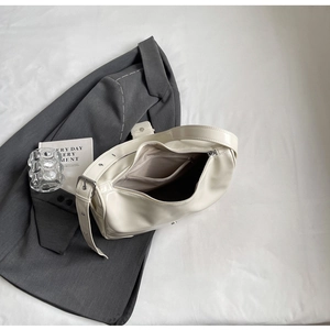 Detailed view of cream patent leather shoulder bag showing interior lining and zipper pocket