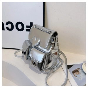 Close-up of metallic silver backpack featuring heart accents and chain-linked strap detail
