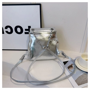 Detailed view of silver metallic mini backpack featuring chain strap and pleated texture