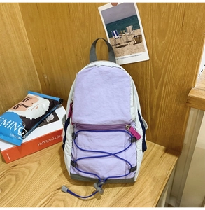 Dettaglio di uno zaino outdoor in nylon con design a contrasto di colori viola e grigio