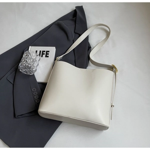 Detailed view of cream leather tote bag with elegant chain strap and golden hardware
