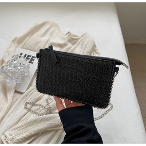 Detail of woven black phone bag with silver beaded trim and metal chain strap