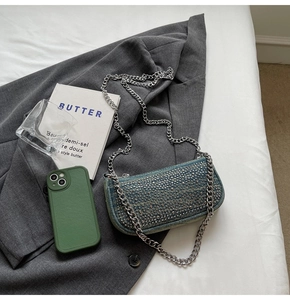 Detail of blue denim shoulder bag with silver metallic studs and chunky chain strap