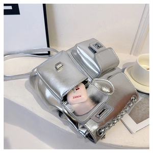 Detail of silver metallic bucket bag showing multiple pockets and storage for headphones