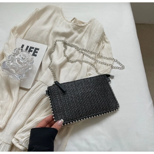 Detailed view of black woven texture bag with silver bead trim and metal chain strap
