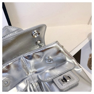 Detail of silver metallic textured backpack with shiny metal turn-lock and magnetic snap