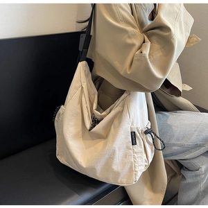 Detail of canvas tote bag showing side drawstring and CHUANGMI brand tag on nylon fabric