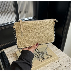 Detail of straw woven clutch bag with silver bead trim and metal chain strap