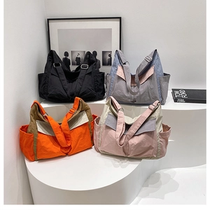 Detailed view of large nylon tote bags in four colors with adjustable shoulder straps