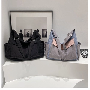 Detail view of large nylon messenger bags showing side pockets and adjustable straps