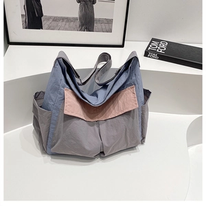 Detail view of the multi-color canvas crossbody bag showing side pockets and wide strap