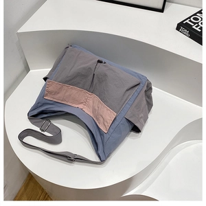 Detail of color-block nylon crossbody bag with wide adjustable strap and metal buckle