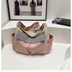 Detailed view of large canvas messenger bag with multi-color pockets and nylon texture