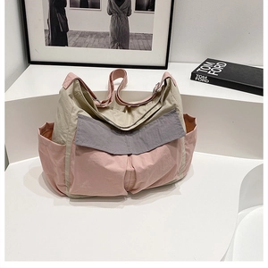 Detailed macro view of nylon crossbody bag with multi-pocket design and contrast colors