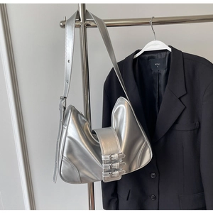 Macro view of metallic silver crescent bag featuring triple buckle straps on premium PU