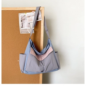 Detail of color-block canvas crossbody bag featuring utility pockets and adjustable strap