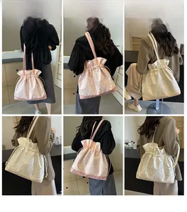 Detail view of pink and off-white drawstring tote bags with jacquard texture on shoulder