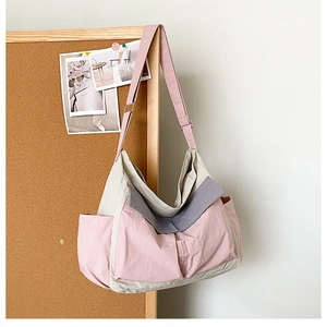 Detail view of pink and grey canvas crossbody bag with multiple functional utility pockets