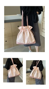 Detail of pink floral jacquard tote bag with drawstring closure and leather base