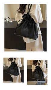 Close-up of black drawstring shoulder bag featuring embossed floral jacquard fabric texture