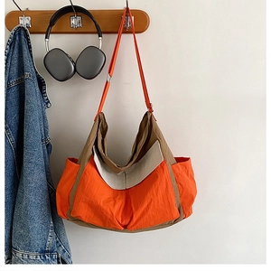 Macro detail of tricolor patchwork canvas hobo bag showing nylon texture and side pockets