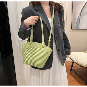 Detail of avocado green pleated shoulder bag with golden hardware and adjustable strap