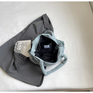 Détail d'un sac à main matelassé bleu clair avec doublure intérieure noire et poche