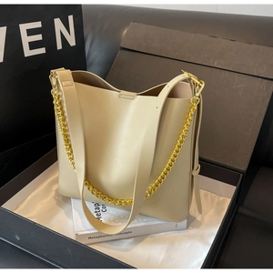 Detail shot of a beige chain tote bag showing fine stitching and luxury packaging