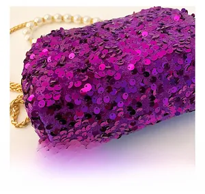 Detail der lila Pailletten-Tasche mit Perlenriemen und metallischen Kettengliedern