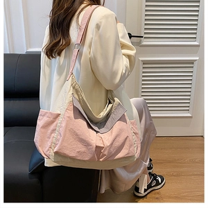 Side view of spacious pink and khaki canvas messenger bag showing large capacity pockets