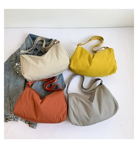 Detailoverzicht van vier kleurrijke nylon hobo-tassen met verstelbare schouderbanden