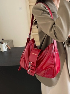 Glossy red faux leather underarm bag with three silver buckles in a retro chic style