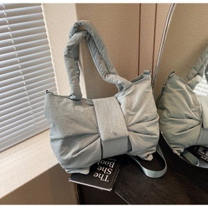 Vue détaillée du design de grand nœud sur ce sac à épaule en nylon bleu clair