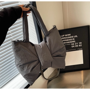 Gros plan détaillé du sac cabas gris foncé en forme de nœud avec texture plissée élégante