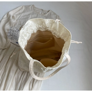 Macro shot of the spacious interior with zippered pocket and floral embroidery drawstring