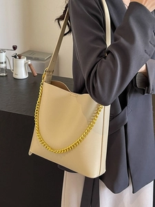 Minimalist beige leather tote bag with chunky gold chain strap for women in summer style