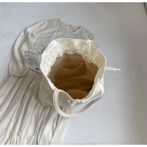 Top view of beige drawstring tote bag showing inner zipper pocket and fabric lining