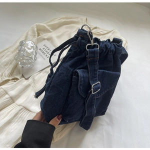 Detailansicht der dunkelblauen Denim-Beuteltasche mit Metallschnalle und Kordelzug