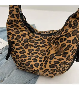 Detail of leopard print canvas crescent bag with black zipper and woven rope puller