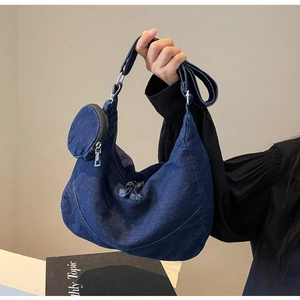 Dettaglio della borsa a mezzaluna in denim blu con borsellino rotondo e zip in metallo argento