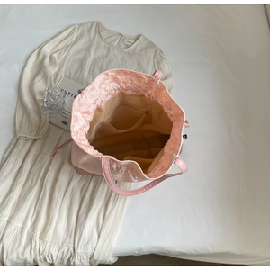 Close-up of pink drawstring tote with floral lining and interior zipper pocket