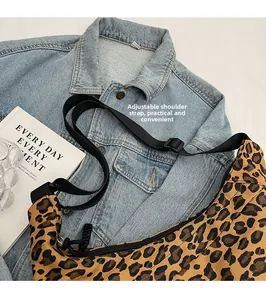 Leopard print crossbody bag detail showing the adjustable black nylon shoulder strap